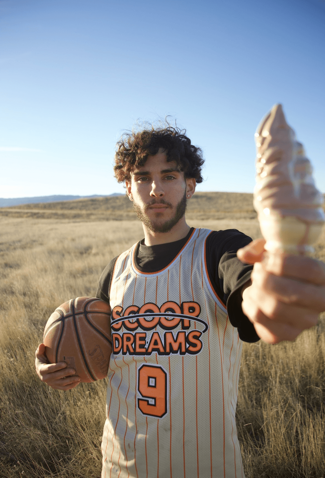 Devan Minouei, Scoop Dreams founder, holding a basketball and soft serve in Vacaville CA